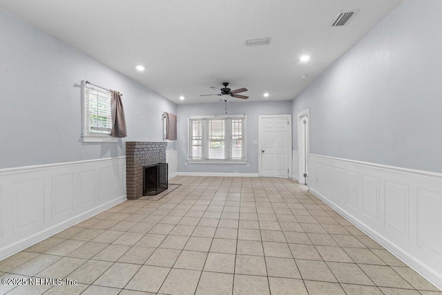 4537 Springfield Blvd, Jacksonville, FL 32206 - unfurnished living room featuring a ceiling fan, a wainscoted wall, recessed lighting, a fireplace, and light tile patterned floors