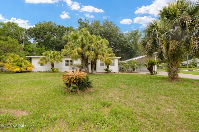 1927 Lakewood Cir N, Jacksonville, FL 32207 - view of front facade with a front lawn, concrete driveway, stucco siding, and a carport