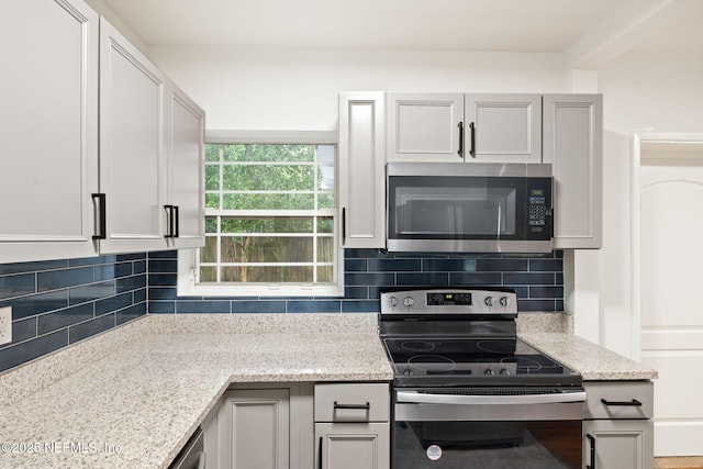1927 Lakewood Cir N, Jacksonville, FL 32207 - kitchen with appliances with stainless steel finishes, decorative backsplash, and light stone countertops