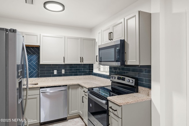 1927 Lakewood Cir N, Jacksonville, FL 32207 - kitchen with appliances with stainless steel finishes, backsplash, and light stone countertops