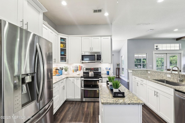 1708 Bridled Tern Ct, Fleming Island, FL 32003 - kitchen featuring stainless steel appliances, a sink, dark wood-style flooring, decorative backsplash, and white cabinets