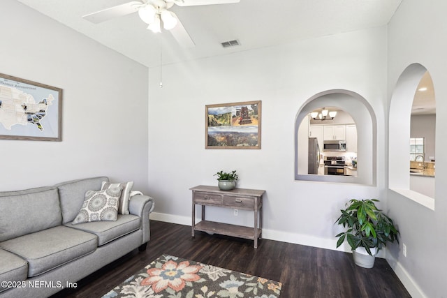 1708 Bridled Tern Ct, Fleming Island, FL 32003 - living area with dark wood finished floors, ceiling fan, baseboards, and arched walkways