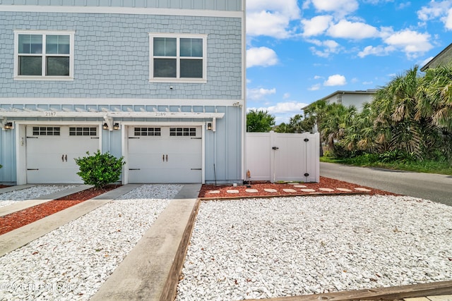 2189 2nd St S, Jacksonville Beach, FL 32250 - view of front of home with board and batten siding, a garage, a gate, and driveway