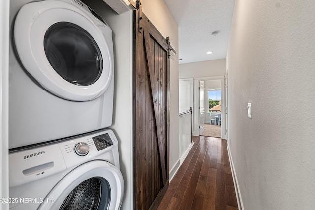 2189 2nd St S, Jacksonville Beach, FL 32250 - laundry area featuring a barn door, estacked washer and dryer, baseboards, dark wood finished floors, and a textured wall