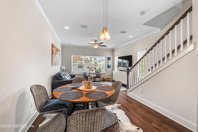 2189 2nd St S, Jacksonville Beach, FL 32250 - dining room with crown molding, baseboards, dark wood-style flooring, ceiling fan, and stairs