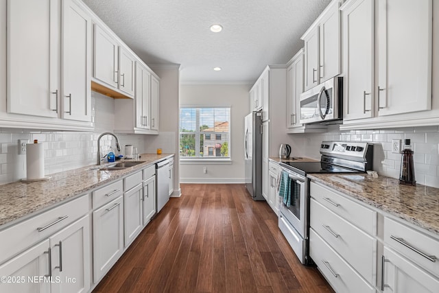 2189 2nd St S, Jacksonville Beach, FL 32250 - kitchen featuring stainless steel appliances, a sink, baseboards, white cabinetry, and dark wood-style flooring