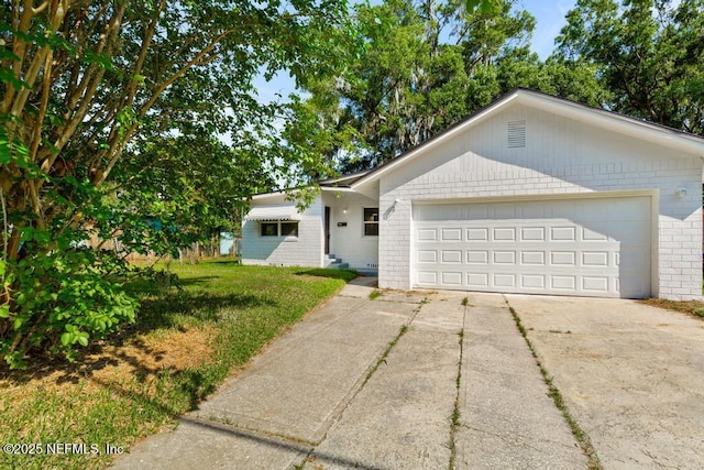 4249 Lockhart Dr, Jacksonville, FL 32209 - ranch-style home with brick siding, driveway, an attached garage, and a front yard