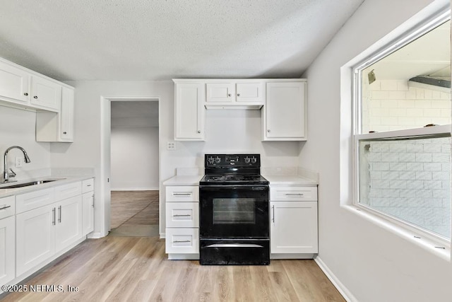 4249 Lockhart Dr, Jacksonville, FL 32209 - kitchen with black / electric stove, a sink, light wood-type flooring, light countertops, and white cabinetry