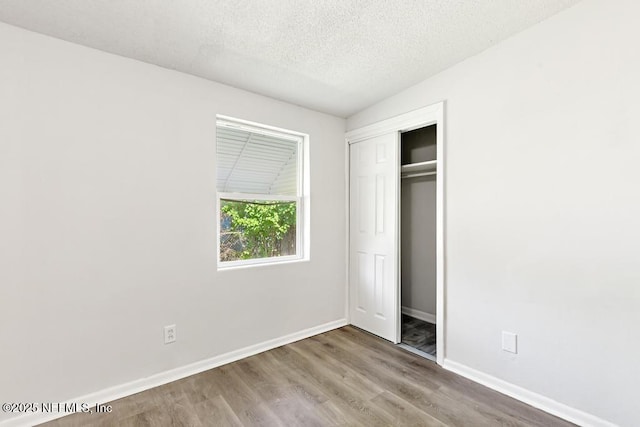 4249 Lockhart Dr, Jacksonville, FL 32209 - unfurnished bedroom with baseboards, wood finished floors, a textured ceiling, and a closet