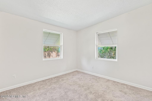 4249 Lockhart Dr, Jacksonville, FL 32209 - carpeted empty room with healthy amount of natural light, a textured ceiling, and baseboards