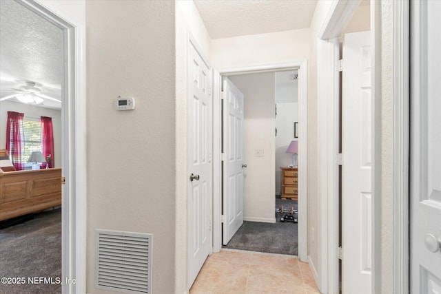 133 Divi Divi Dr, San Mateo, FL 32187 - corridor featuring a textured ceiling, light tile patterned floors, light colored carpet, and a textured wall