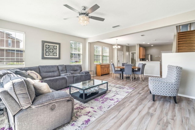 6033 Bartram Village Dr, Jacksonville, FL 32258 - living room with light wood finished floors, a ceiling fan, a chandelier, and baseboards