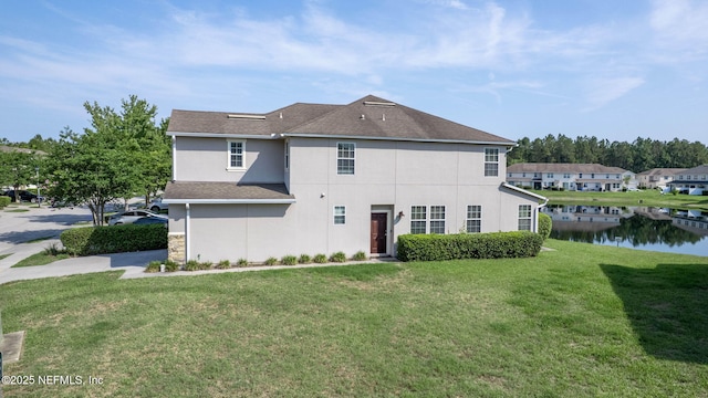 6033 Bartram Village Dr, Jacksonville, FL 32258 - back of house with a lawn, stucco siding, a water view, and roof with shingles