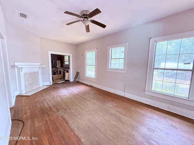 2771 Sunnyside St, Jacksonville, FL 32254 - unfurnished living room with hardwood / wood-style flooring, baseboards, a ceiling fan, and a tile fireplace