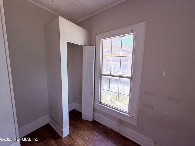 2771 Sunnyside St, Jacksonville, FL 32254 - unfurnished bedroom featuring a textured ceiling, dark wood-type flooring, and baseboards