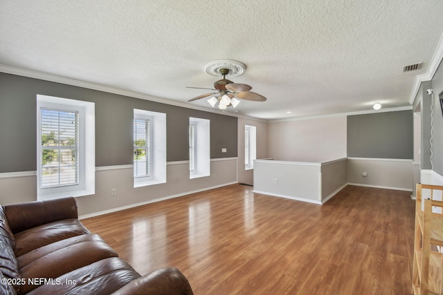 116 Nunna Rock Trl, Saint Augustine, FL 32092 - unfurnished living room featuring crown molding, a ceiling fan, a textured ceiling, wood finished floors, and baseboards