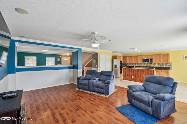 116 Nunna Rock Trl, Saint Augustine, FL 32092 - living room featuring ornamental molding, a textured ceiling, light wood-type flooring, a ceiling fan, and baseboards