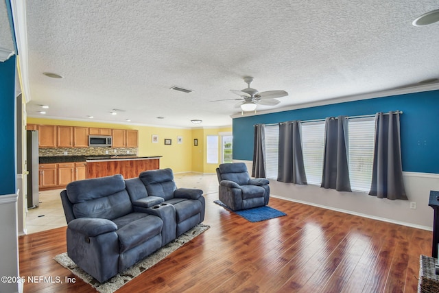 116 Nunna Rock Trl, Saint Augustine, FL 32092 - living room with a ceiling fan, light wood-type flooring, baseboards, crown molding, and a textured ceiling