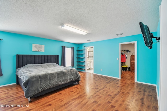 116 Nunna Rock Trl, Saint Augustine, FL 32092 - bedroom with wood finished floors, a textured ceiling, baseboards, and a walk in closet