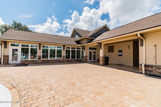 116 Nunna Rock Trl, Saint Augustine, FL 32092 - back of house with french doors, stone siding, stucco siding, and a shingled roof