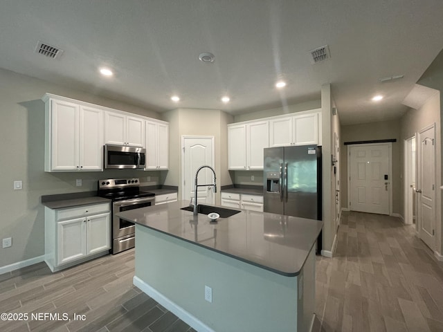 10312 Benson Lake Dr, Jacksonville, FL 32222 - kitchen with appliances with stainless steel finishes, light wood-style floors, baseboards, a sink, and white cabinets