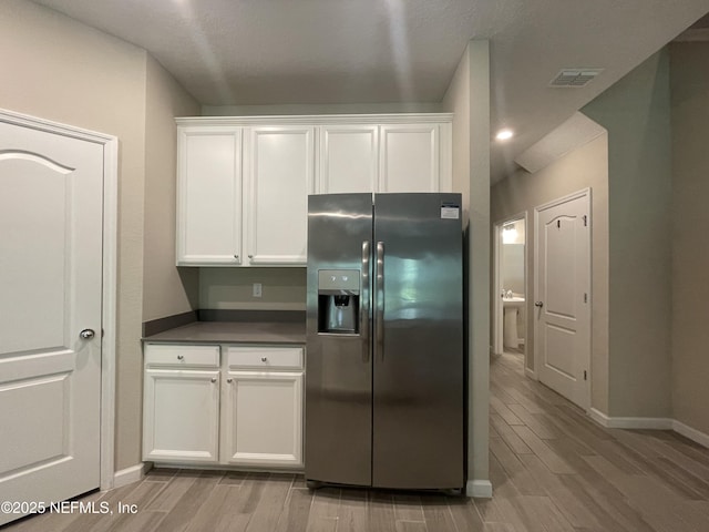 10312 Benson Lake Dr, Jacksonville, FL 32222 - kitchen featuring stainless steel fridge with ice dispenser, light wood finished floors, baseboards, and dark countertops