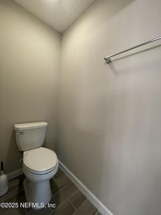 10312 Benson Lake Dr, Jacksonville, FL 32222 - bathroom with baseboards, toilet, and wood finished floors