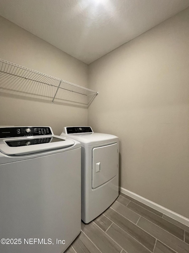 10312 Benson Lake Dr, Jacksonville, FL 32222 - washroom featuring washing machine and dryer, wood finish floors, and baseboards