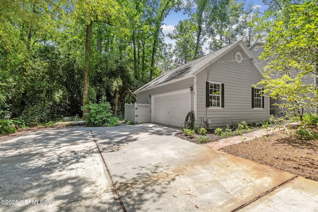 2153 Mills Rd, Jacksonville, FL 32216 - view of property exterior featuring driveway, an attached garage, and a shingled roof