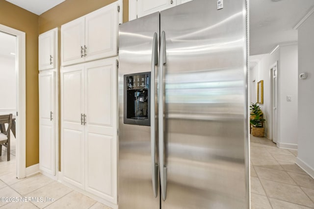 2153 Mills Rd, Jacksonville, FL 32216 - kitchen featuring stainless steel refrigerator with ice dispenser, light tile patterned floors, baseboards, and white cabinets