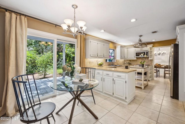 2153 Mills Rd, Jacksonville, FL 32216 - kitchen with a chandelier, freestanding refrigerator, light countertops, a sink, and recessed lighting