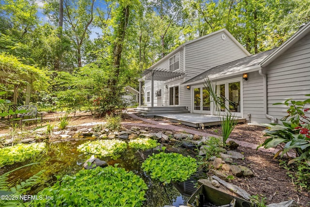 2153 Mills Rd, Jacksonville, FL 32216 - rear view of property featuring a wooden deck, french doors, a pergola, and a small pond