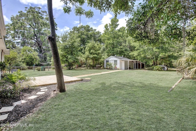 3904 Peach Dr, Jacksonville, FL 32246 - view of green lawn with a deck, an outbuilding, and view of wooded area