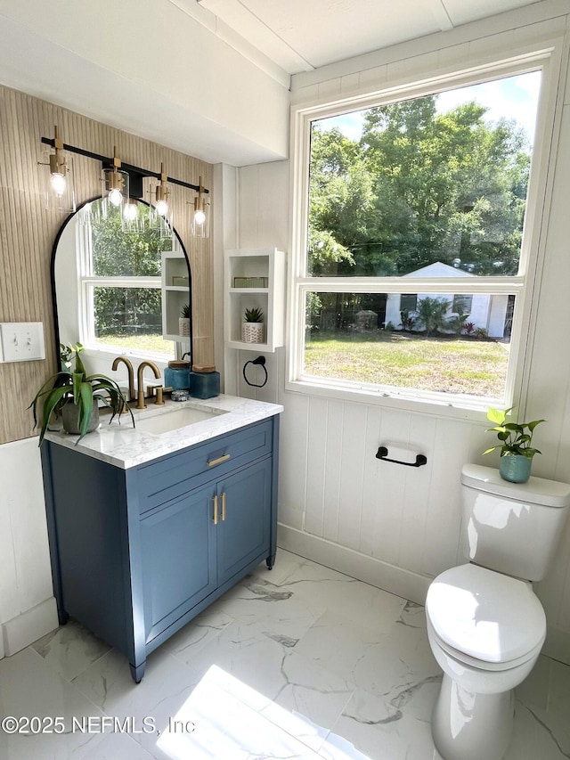 3904 Peach Dr, Jacksonville, FL 32246 - bathroom with marble finish flooring, vanity, toilet, and wood walls