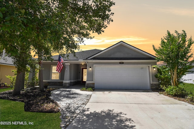 75 Codman Dr, Saint Augustine, FL 32084 - view of front of house with stucco siding, driveway, a garage, and stone siding