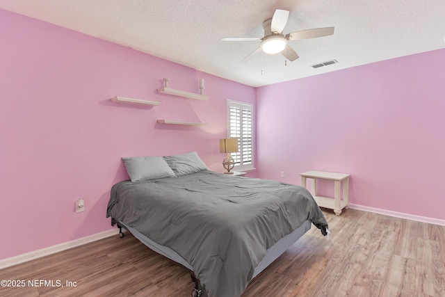 75 Codman Dr, Saint Augustine, FL 32084 - bedroom with wood finished floors, baseboards, ceiling fan, and a textured ceiling