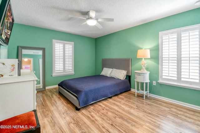 75 Codman Dr, Saint Augustine, FL 32084 - bedroom featuring wood finished floors, baseboards, a textured ceiling, a ceiling fan, and freestanding refrigerator