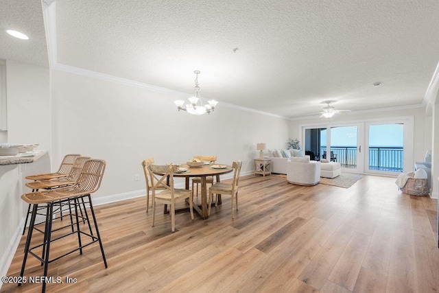 1201 1st St N Unit 1002, Jacksonville Beach, FL 32250 - dining room with a textured ceiling, light wood-type flooring, crown molding, a chandelier, and baseboards