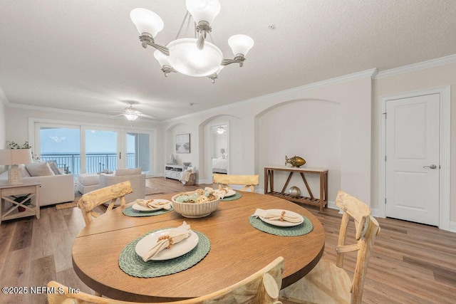 1201 1st St N Unit 1002, Jacksonville Beach, FL 32250 - dining space featuring light wood-style flooring, ornamental molding, a chandelier, ceiling fan, and arched walkways