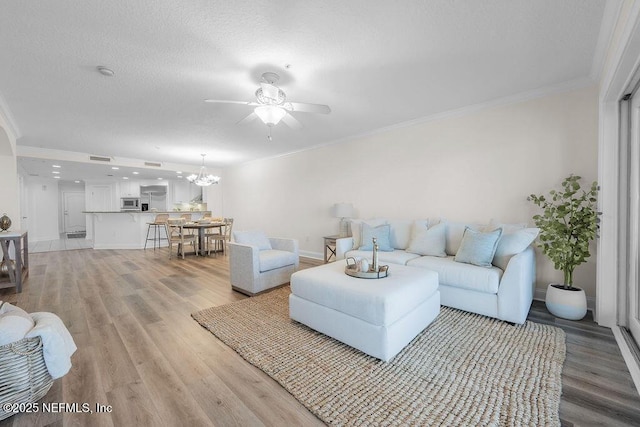 1201 1st St N Unit 1002, Jacksonville Beach, FL 32250 - living area with light wood-style floors, ceiling fan, ornamental molding, a chandelier, and baseboards