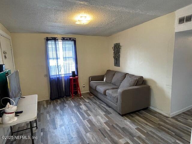 843 Line St, Jacksonville, FL 32209 - living area with wood finished floors, a textured ceiling, and baseboards