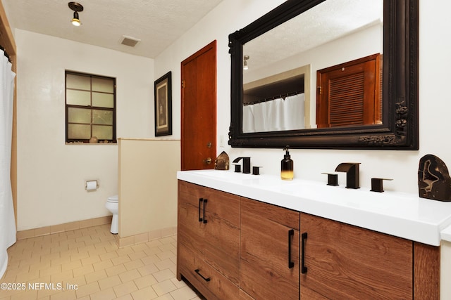3111 Old Port Cir E, Jacksonville, FL 32216 - bathroom with double vanity, toilet, tile patterned floors, baseboards, and a textured ceiling