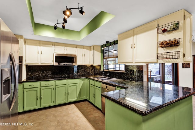 3111 Old Port Cir E, Jacksonville, FL 32216 - kitchen featuring green cabinets, stainless steel appliances, a sink, a peninsula, and a tray ceiling