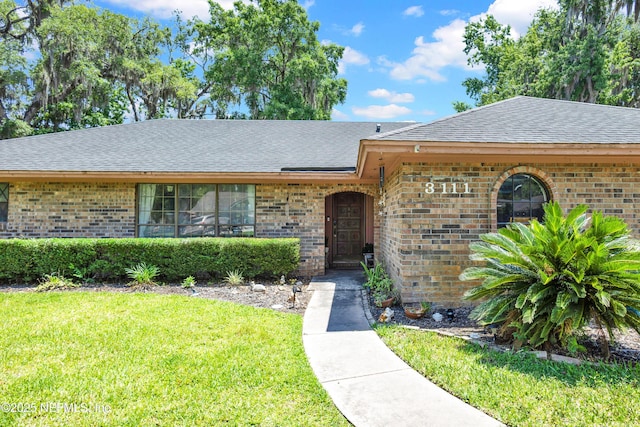 3111 Old Port Cir E, Jacksonville, FL 32216 - view of front of property with roof with shingles, a front yard, and brick siding