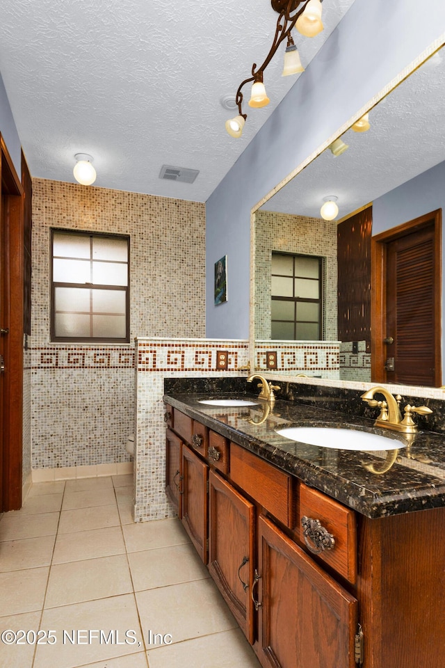 3111 Old Port Cir E, Jacksonville, FL 32216 - bathroom featuring double vanity, toilet, a textured ceiling, tile patterned floors, and wallpapered walls