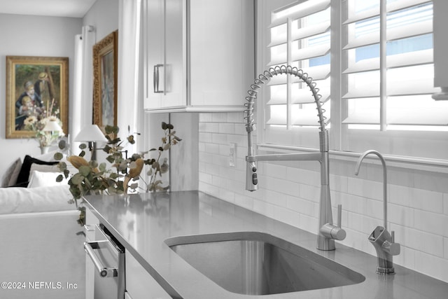 45 Lantern Post Way, Ponte Vedra, FL 32081 - kitchen view of backsplash, a sink, white cabinetry, and stainless steel countertops