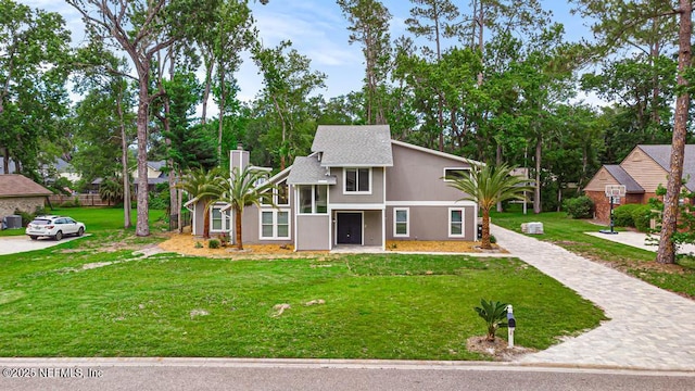 2605 Spreading Oaks Ln, Jacksonville, FL 32223 - view of front of property featuring a chimney, a front lawn, and a shingled roof