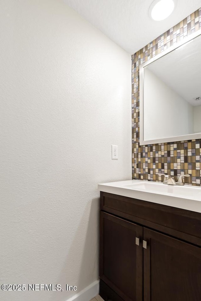 2605 Spreading Oaks Ln, Jacksonville, FL 32223 - bathroom with backsplash, vanity, and baseboards