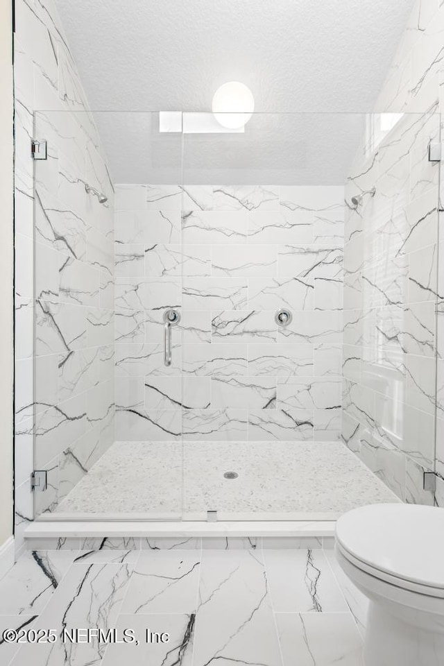 2605 Spreading Oaks Ln, Jacksonville, FL 32223 - bathroom featuring a marble finish shower, toilet, a textured ceiling, and marble finish floors
