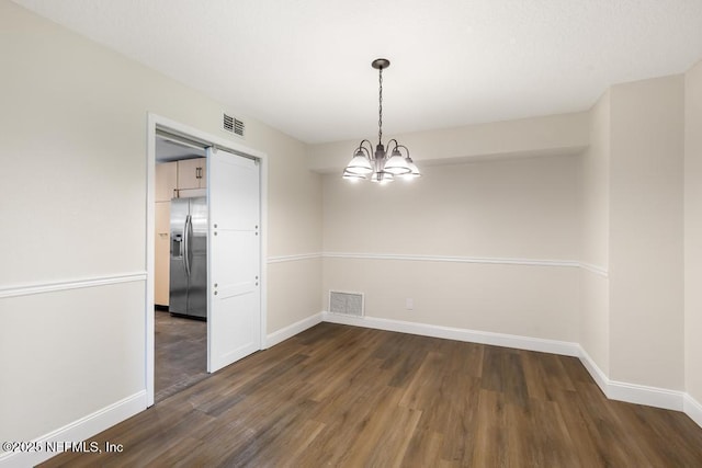 2605 Spreading Oaks Ln, Jacksonville, FL 32223 - empty room featuring dark wood-style flooring, a chandelier, and baseboards